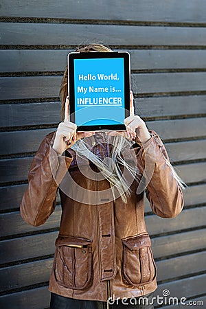 â€œHello world, my name is influencerâ€ text on tablet in young blogger woman hands. Stock Photo